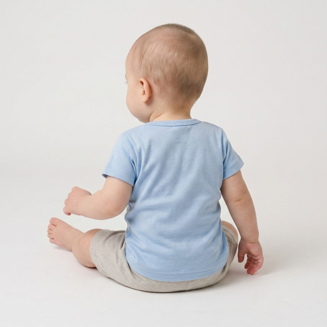 Light blue Bushbaby short-sleeve t-shirt for infants, made from soft jersey knit fabric, seen from the back, paired with