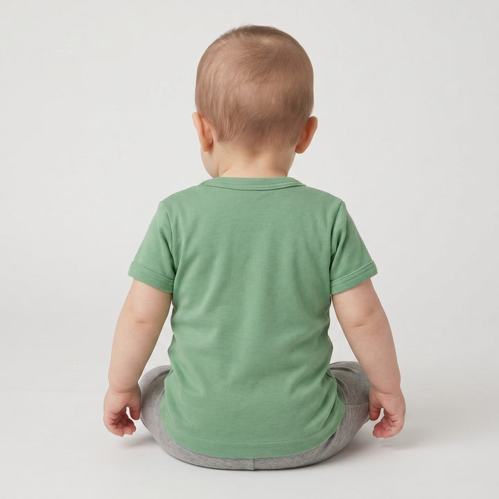 Back view of an infant wearing a short-sleeve sage green Elephant T-Shirt made from soft cotton fabric, paired with grey