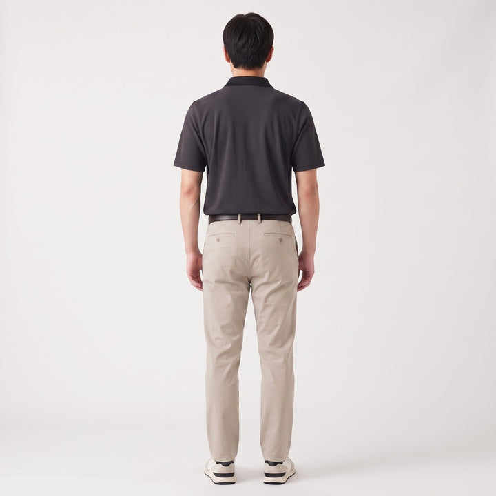 Back view of a man wearing a black Golfer SA Birdseye short-sleeve polo shirt with a refined birdseye texture and classic